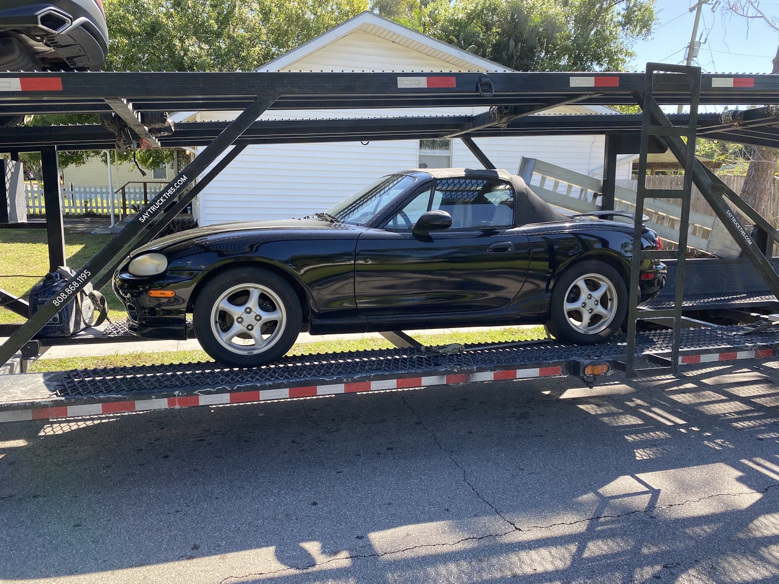 mazda miata on open trailer