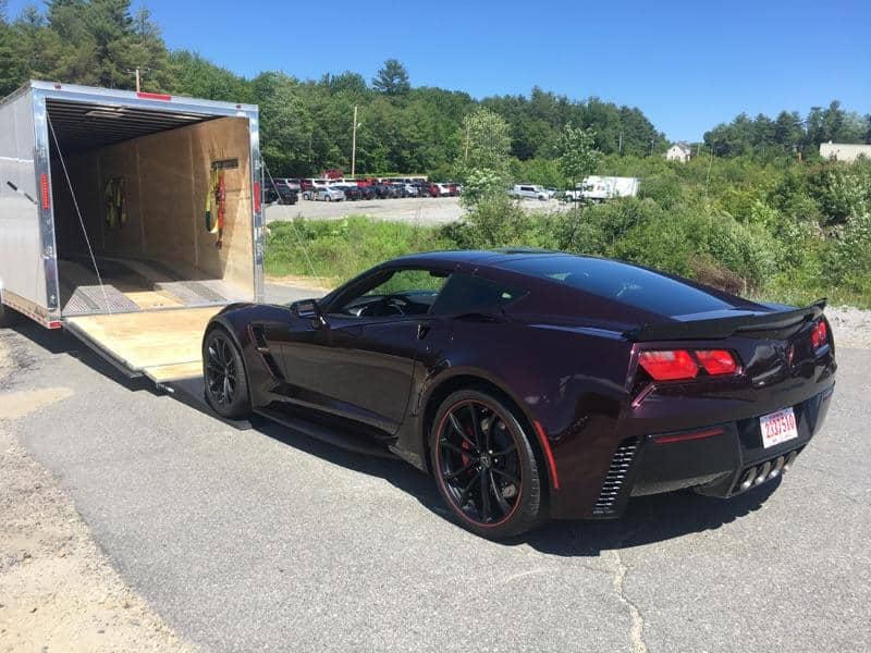 chevy corvette being loaded on an enclosed trailer