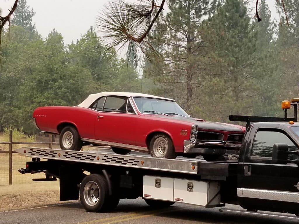 red pontiac on tow truck