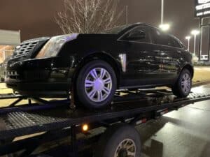 black cadillac on open trailer