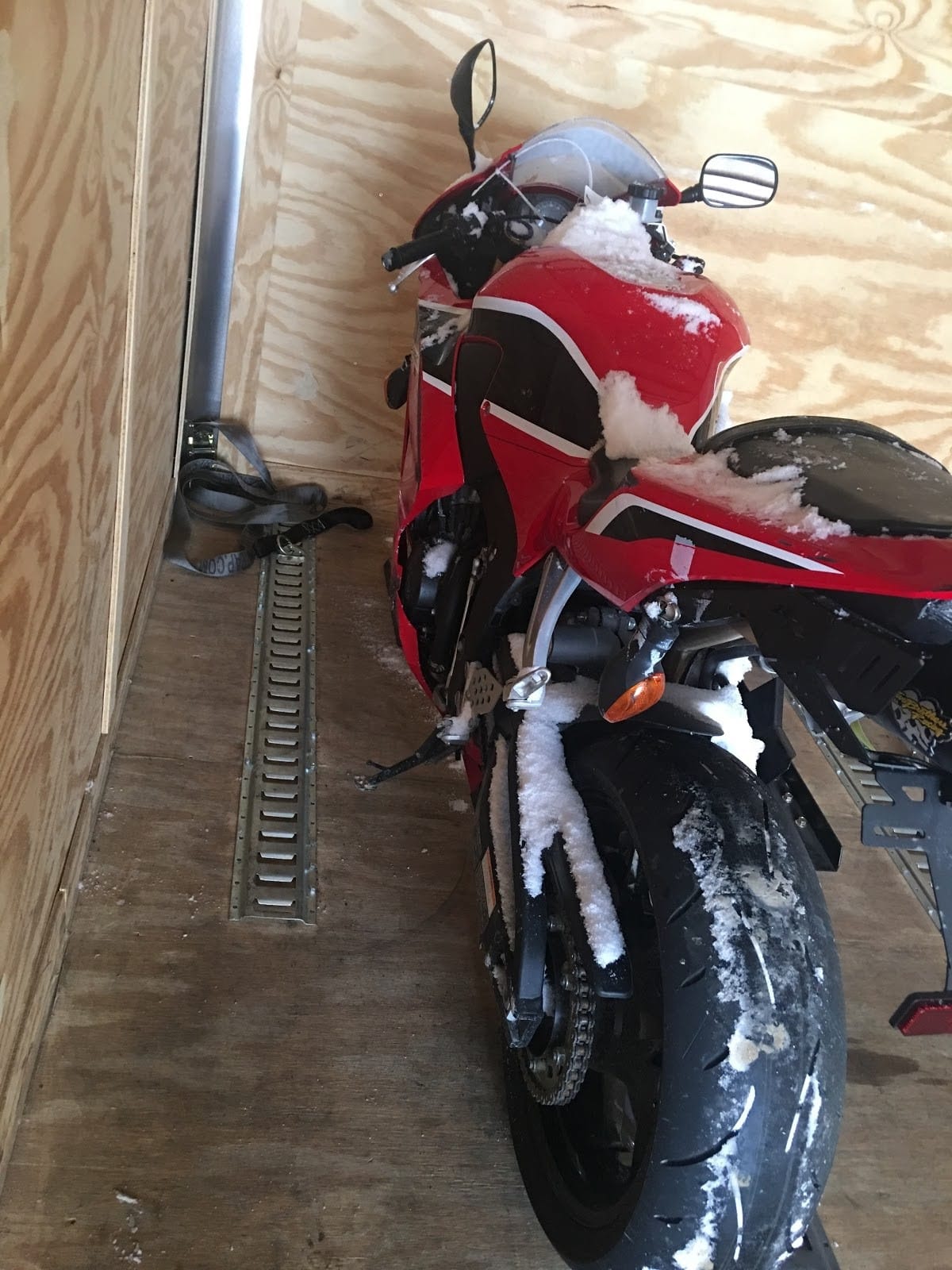 red motor cycle in transport trailer enclosed