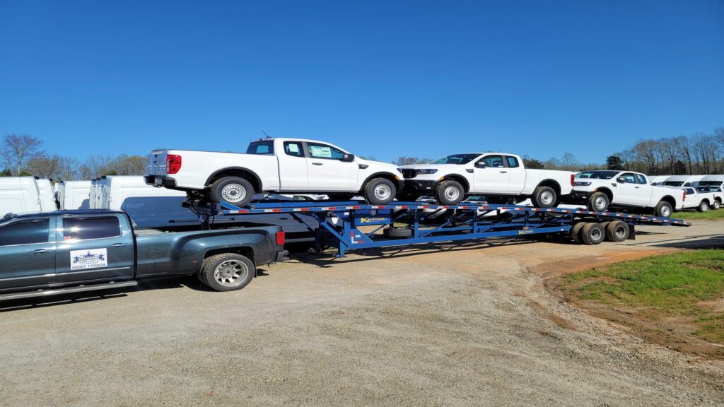 bulk ford ranger trucks being transported on an open trailer