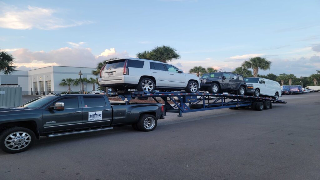 mulitple vehicles being transported on an open trailer