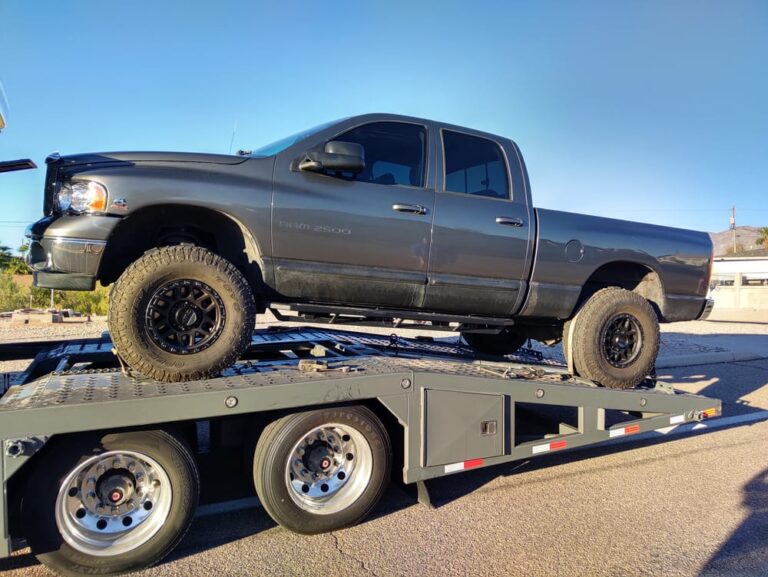 dodge ram 2500 being transported on an open trailer