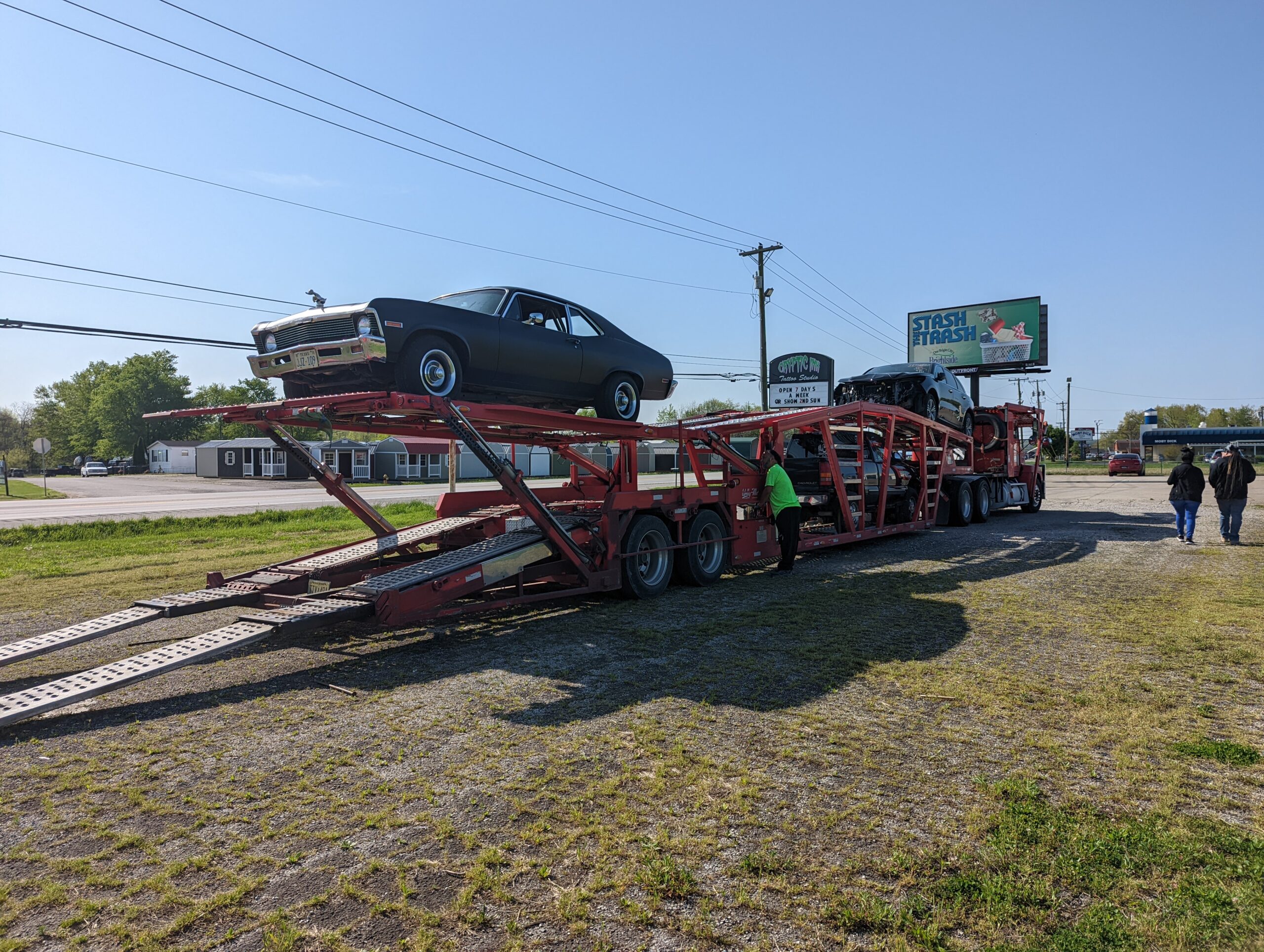 Chevy nova being transported on open trailer