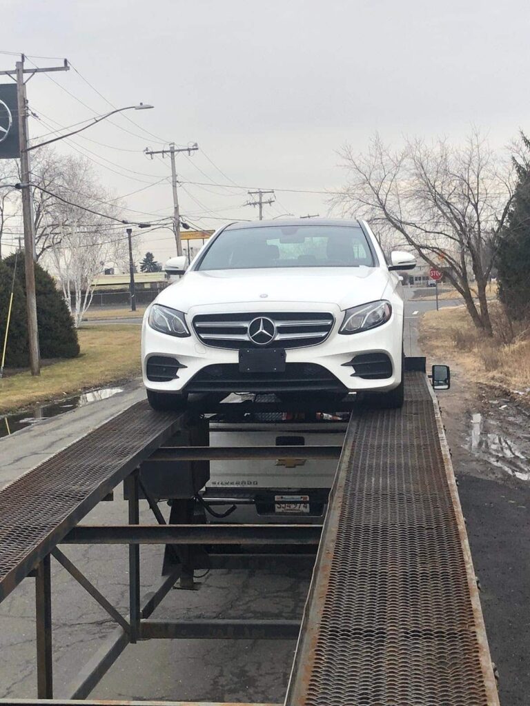 white mercedes benz being transported