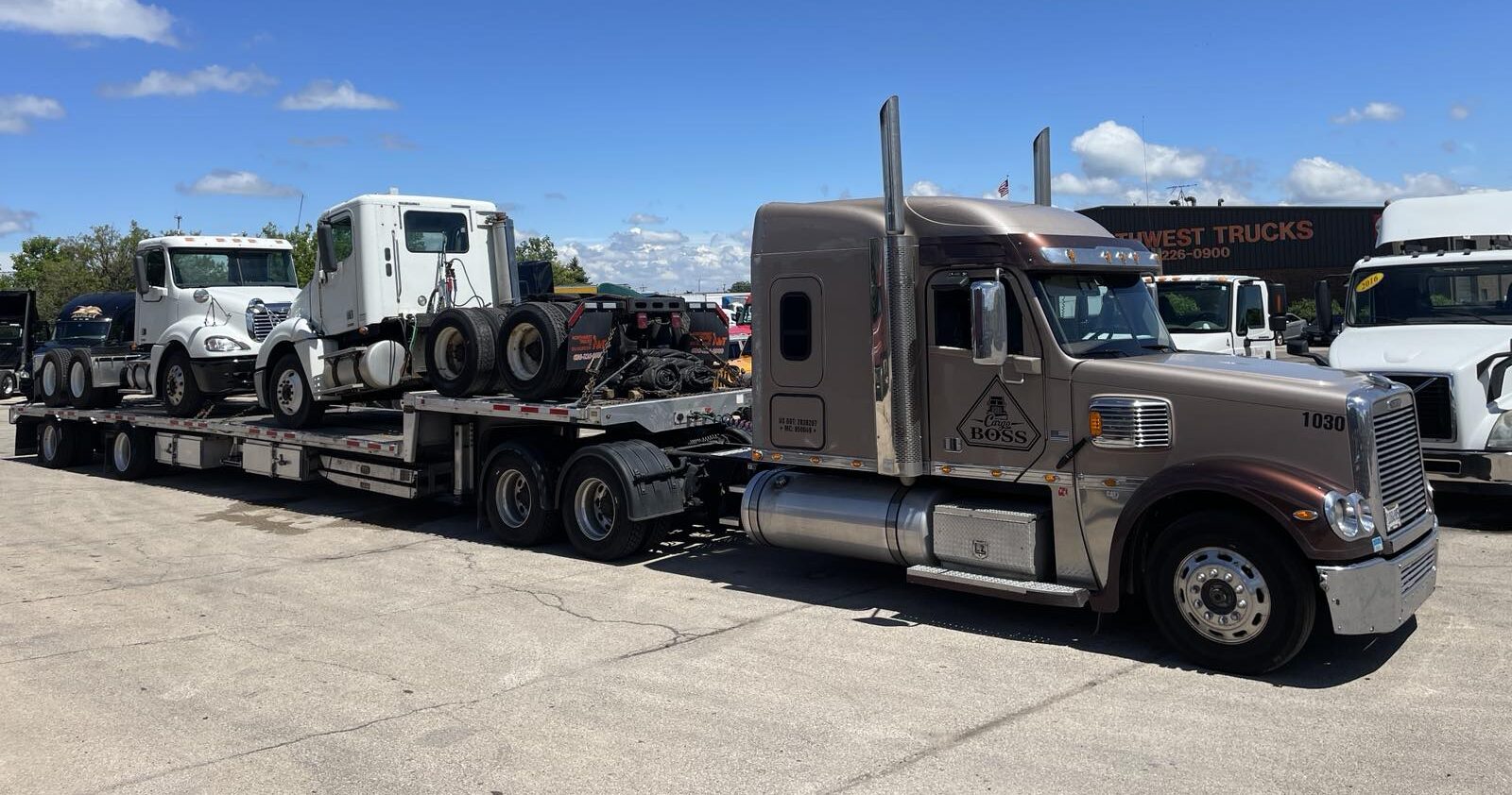 two white semi trucks being transported