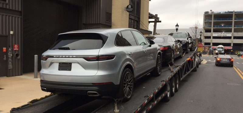 silver porsche suv on trailer for auto transport